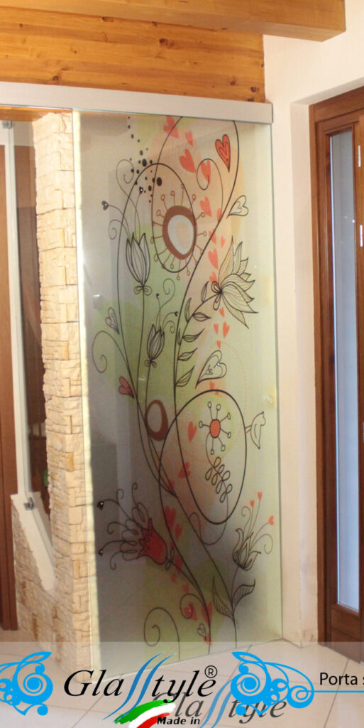 Porta scorrevole in vetro decorata con un'opera d'arte colorata in un ambiente interno.