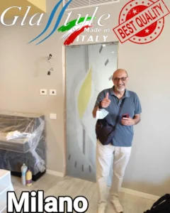 Uomo in piedi davanti ad una porta in vetro, Porta scorrevole interno muro in vetro seglas glasstyle