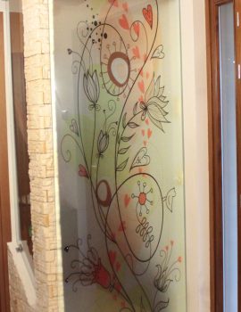Porta scorrevole in vetro decorata con un'opera d'arte colorata in un ambiente interno.