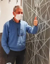 Porta scorrevole in vetro decorata con un'opera d'arte colorata in un ambiente interno.