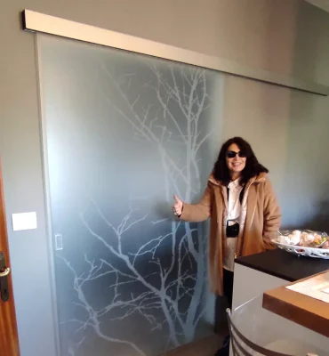 Una donna in piedi davanti a una porta di vetro design.