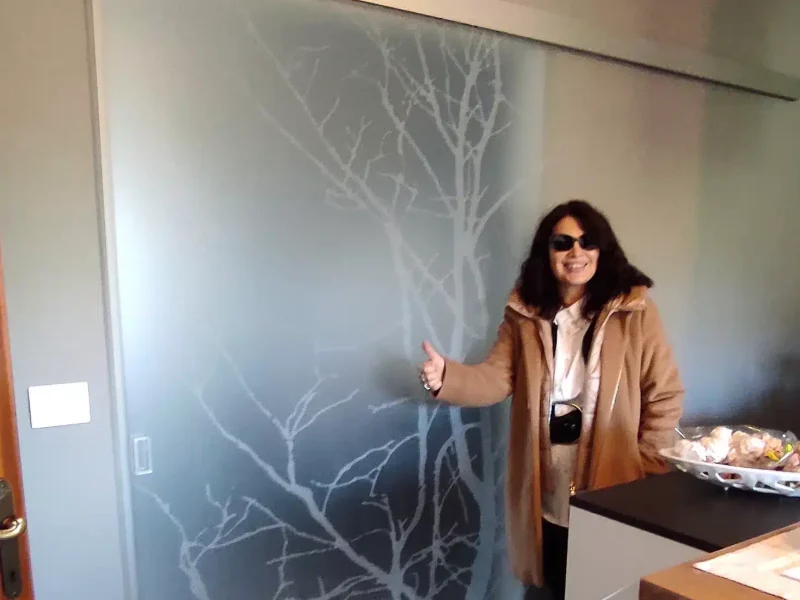 Una donna in piedi davanti a una porta di vetro design.