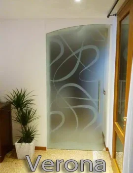 Porta scorrevole in vetro decorata con un'opera d'arte colorata in un ambiente interno.
